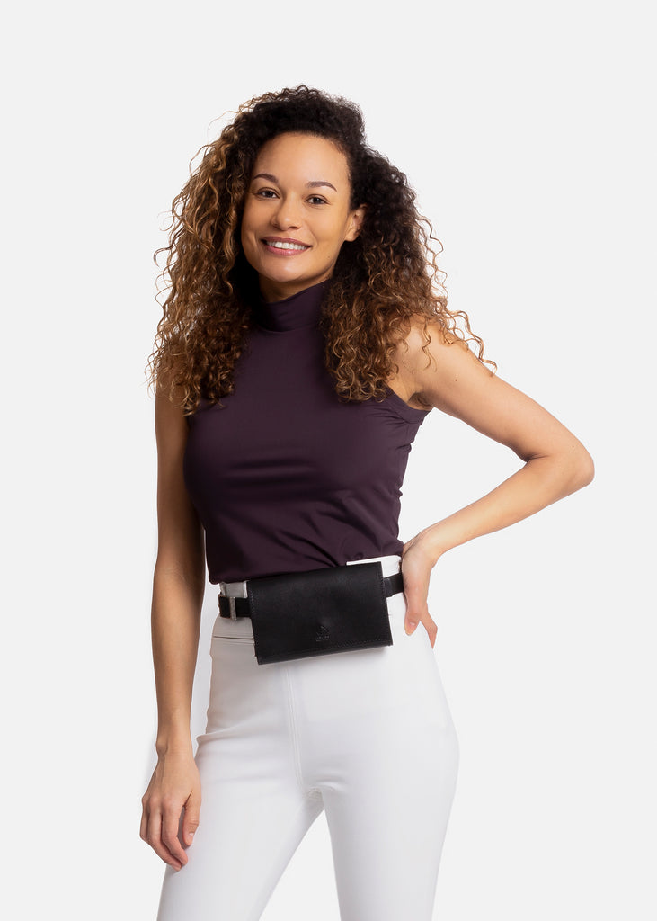 Smiling woman in white breeches and purple tank top