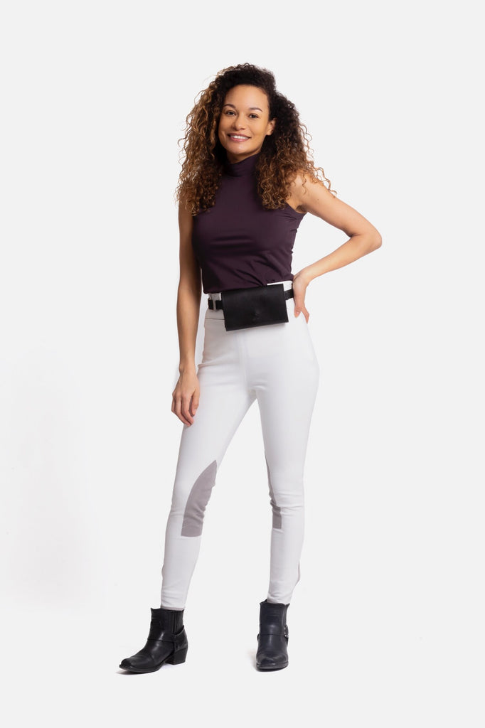 Female model in white high rise riding breeches with grey suede patches.