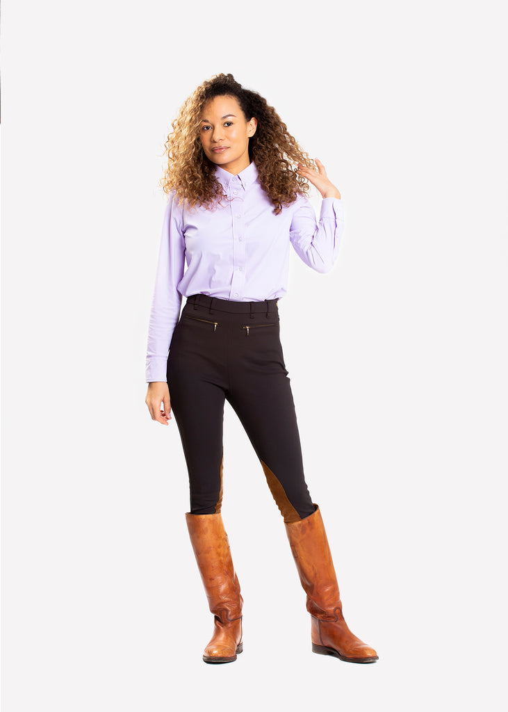 Woman in dark brown high rise breeches. Knee patches in contrast color. 