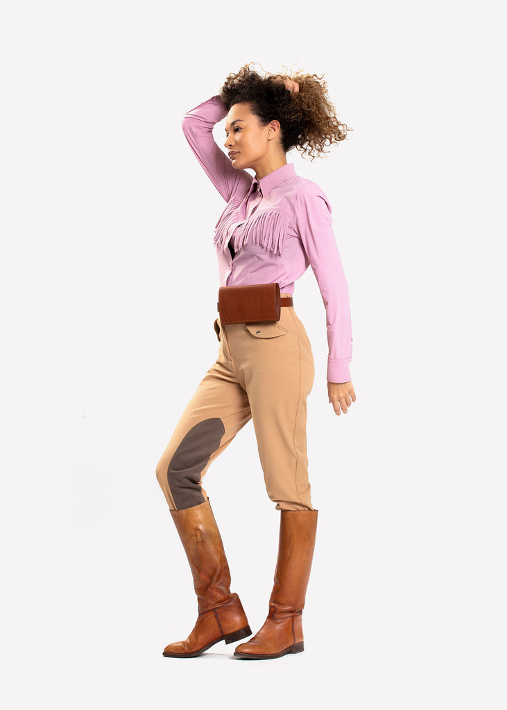Female model in pink rodeo shirt and beige riding breeches