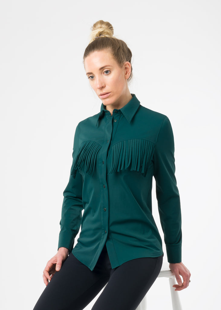 Female model in a studio wearing a green shirt and black trousers